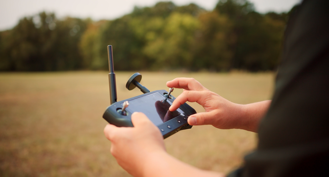 A man is controlling the Discovery 3 drone with a wireless controller.